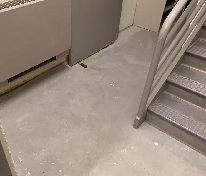 concrete floor with stairs without standing water at he bottom of the stairs 