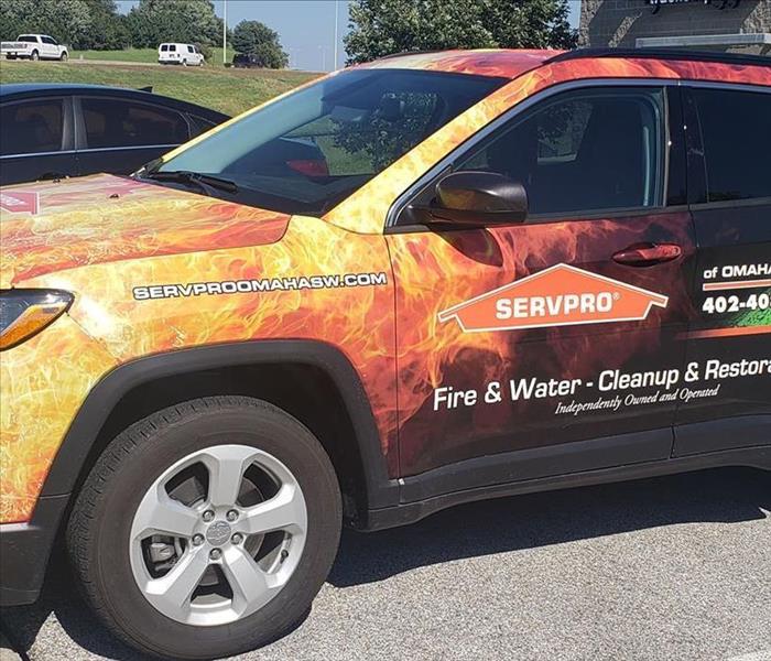 Wrapped Jeep with orange Fire and Green Water with SERVPRO logo and SERVPRO of Omaha Southwest's contact info