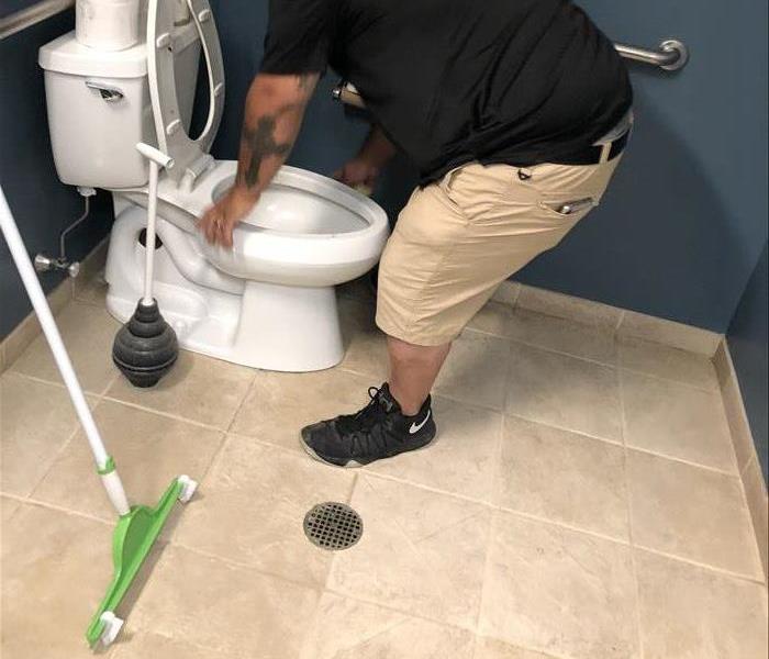 SERVPRO crew member cleaning a bathroom 