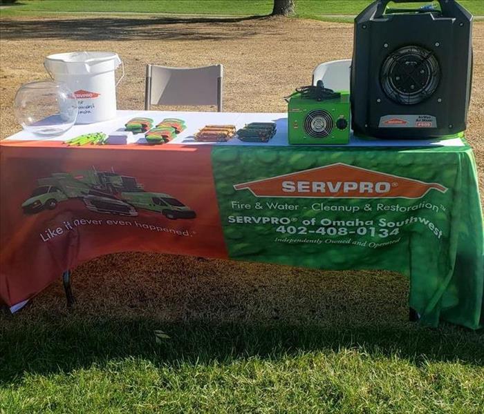 SERVPRO fire and water table cloth with marketing items on top an ozone machine and air dryer on the right side of the table 