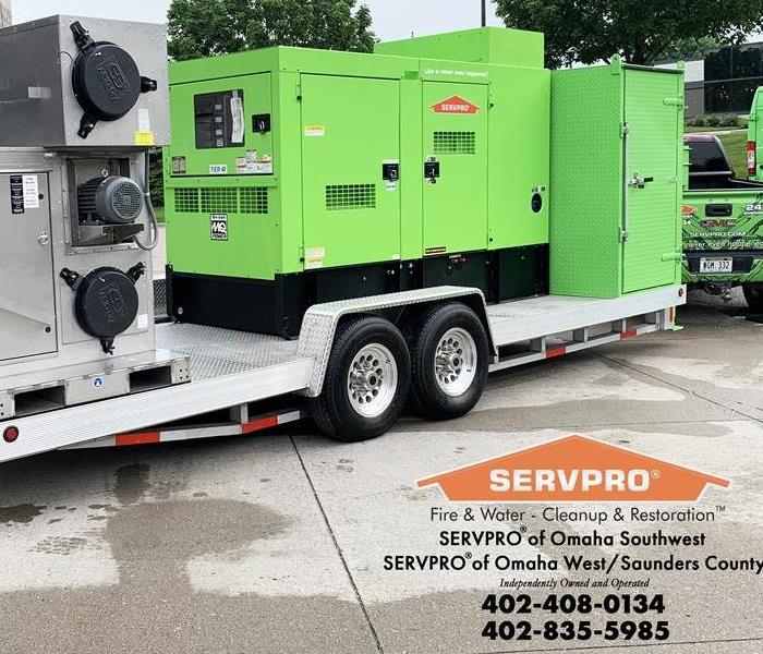 A large green machine on a sliver trailer, says SERVPRO